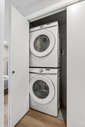 A laundry room with two stacked washing machines. - King Bed | Min to UofC | NEW (Calgary)