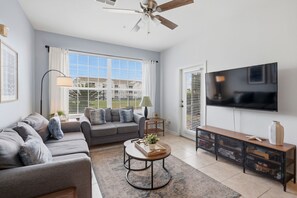 Ein Wohnzimmer mit Sofa, Couchtisch, Fernseher und Stauraumeinheiten.
