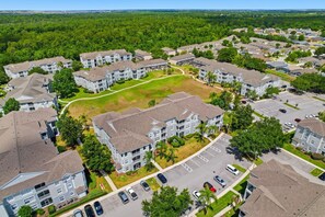 Eine Luftaufnahme eines Wohnkomplexes mit mehreren Mehrfamilienhäusern, Grünflächen und Parkplätzen.