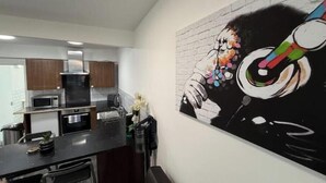 Une cuisine moderne équipée d’un four à micro-ondes, d’une cuisinière et de placards.
