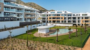 A modern hotel with multiple balconies, a swimming pool, and a mountainous backdrop. - AS EXT Higueron Lomas 4-2b (Fuengirola)