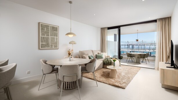 A modern living room with a dining area, a TV, and a large window with a view of a bridge. - AS EXT Higueron Lomas 4-2b (Fuengirola)