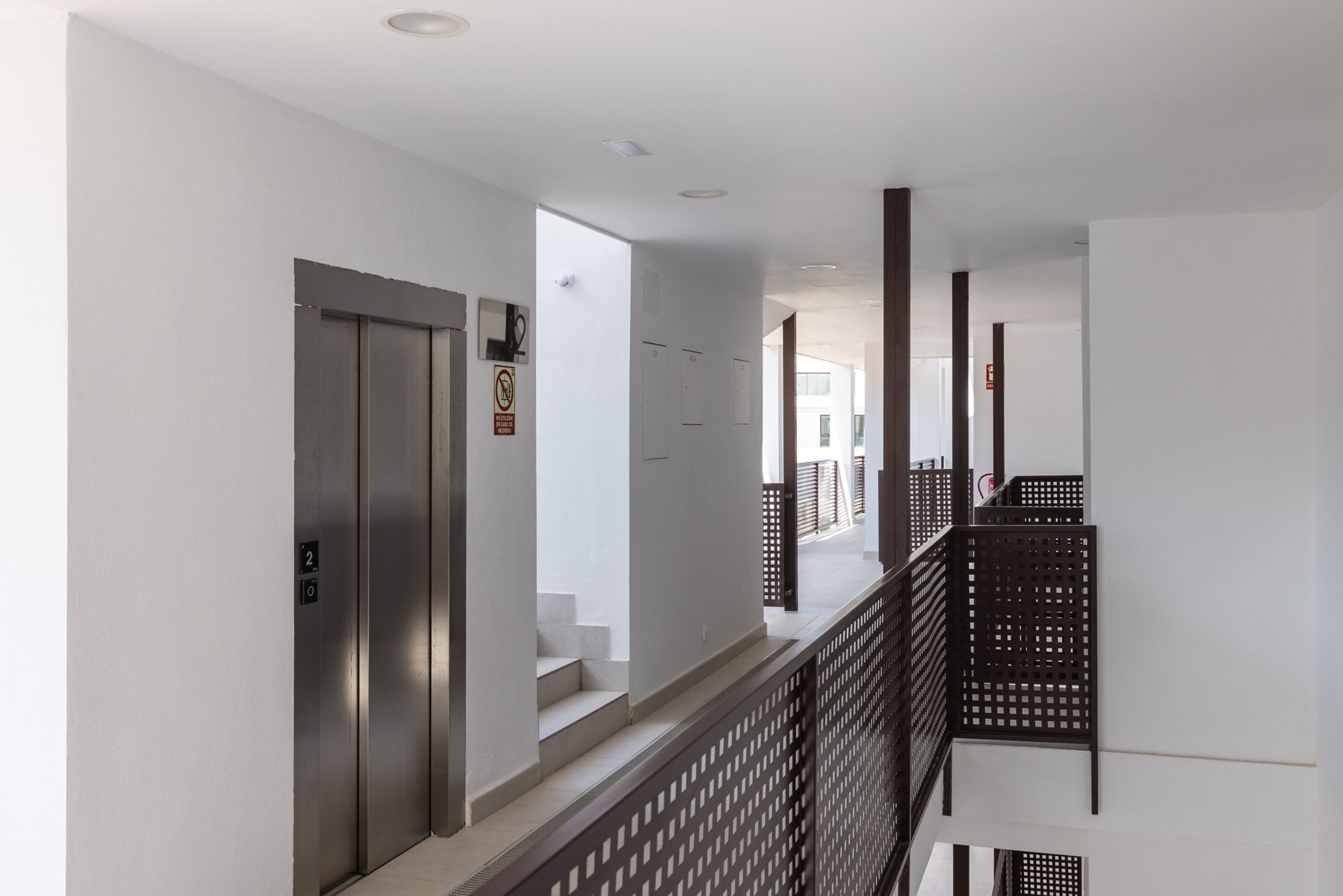 Moderne interiør med trappe, elevator og udsigt ud.