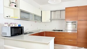 A modern kitchen with white cabinetry, a stainless steel oven, and a white countertop. - S362 – Sirolo, wonderful four-room apartment with garden (Sirolo)