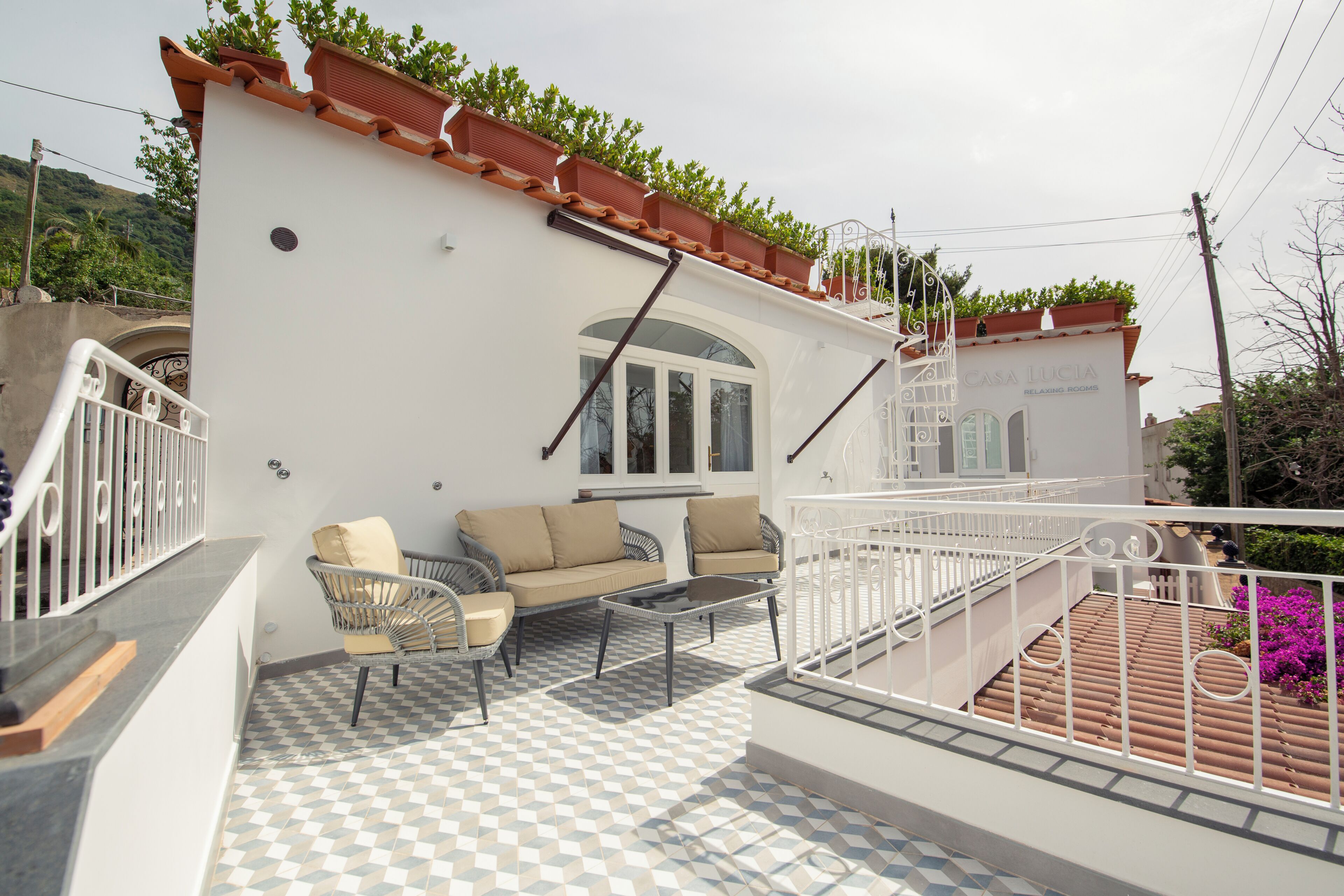 Una terraza con piso a cuadros, un sofá y una silla.
