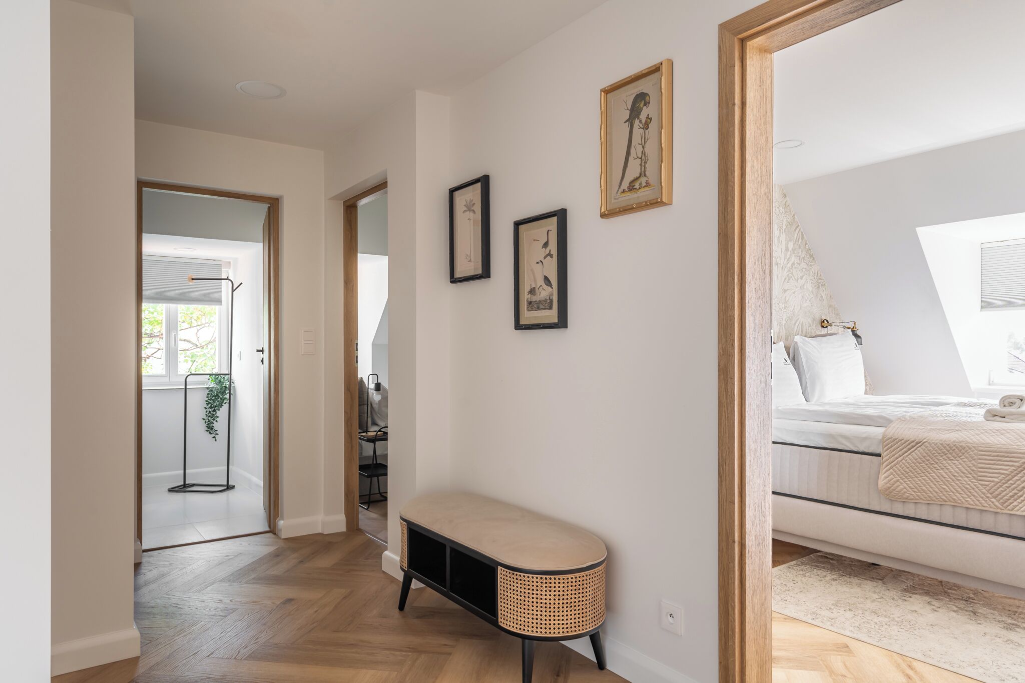 Ein Schlafzimmer mit einem Bett, einem Nachttisch, einer Bank und Bildern an der Wand.
