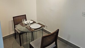 A dining area with a glass table, two chairs, and overhead lighting. - Flat 109 Norte Novo e Completo 204 (Brasília)
