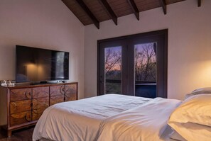 A bedroom with a bed, a TV on a wooden cabinet, and a balcony with a view of the sky. - Views + Hot Tub, Firepit, Fireplace & PS5 (Banner Elk)
