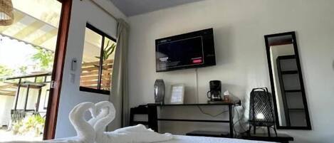 A hotel room with a bed, a television, a desk, and a chair.