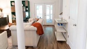 A spacious living room with a sofa, a coffee table, and a bookshelf.