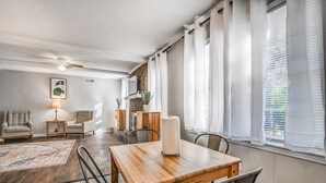 A dining area with a wooden table, chairs, a lamp, and a rug.