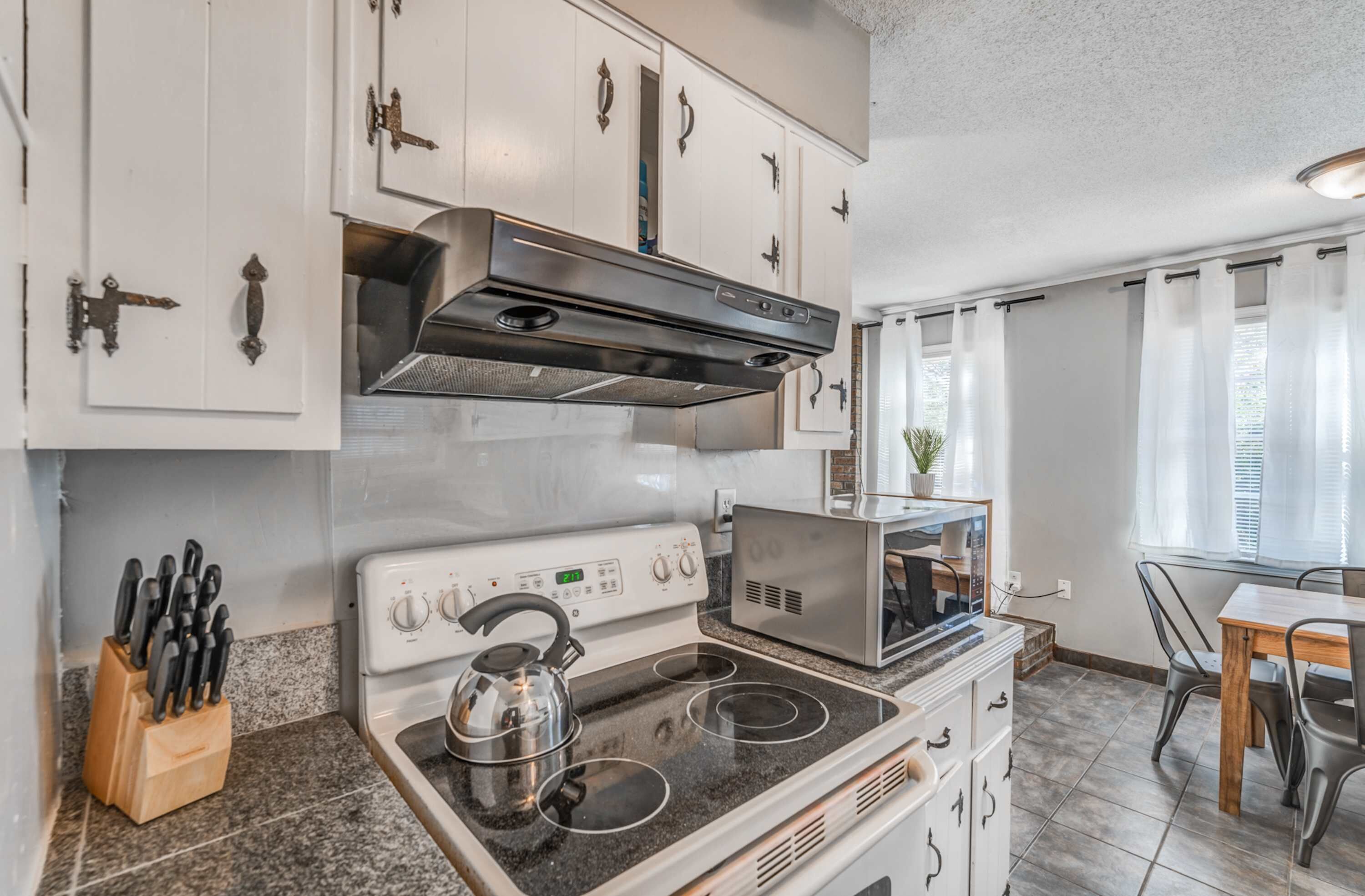 A kitchen with a stove, microwave, and cabinets.