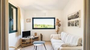 Une chambre avec un lit, une télévision, une petite table et une fenêtre donnant sur un beau paysage.