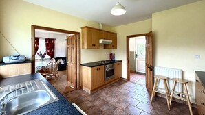 Une cuisine avec des meubles de rangement en bois, un évier et une cuisinière.