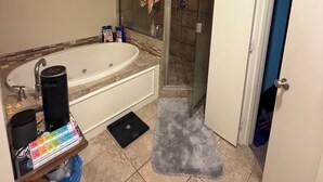 Une salle de bain avec une baignoire, une douche et un porte-serviettes.