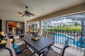 Ein überdachter Außenbereich mit Pool, Sitzgelegenheiten und Blick auf die Landschaft.