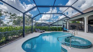 Ein Pool mit Glasdach, Liegestühlen und Blick auf die umliegende Landschaft.