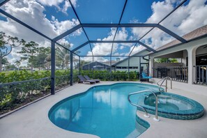 Ein Pool mit Glasdach, Liegestühlen und Blick auf die umliegende Landschaft.