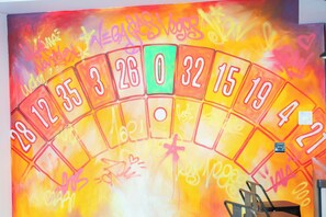 A colorful, graffiti-covered wall with a spinning wheel game. - Las Vegas Party Pad (Sleeps 16) (Liverpool)