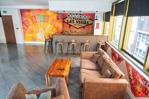 A lobby with a 'Welcome to Fabulous Las Vegas' sign, a bar area, seating arrangements, and a large window. - Las Vegas Party Pad (Sleeps 16) (Liverpool)