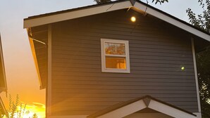 A two-story house with a front porch and a small window. - Stunning Bluff Cottage with Panoramic Puget Sound & Olympic Mountain Views (Seattle)