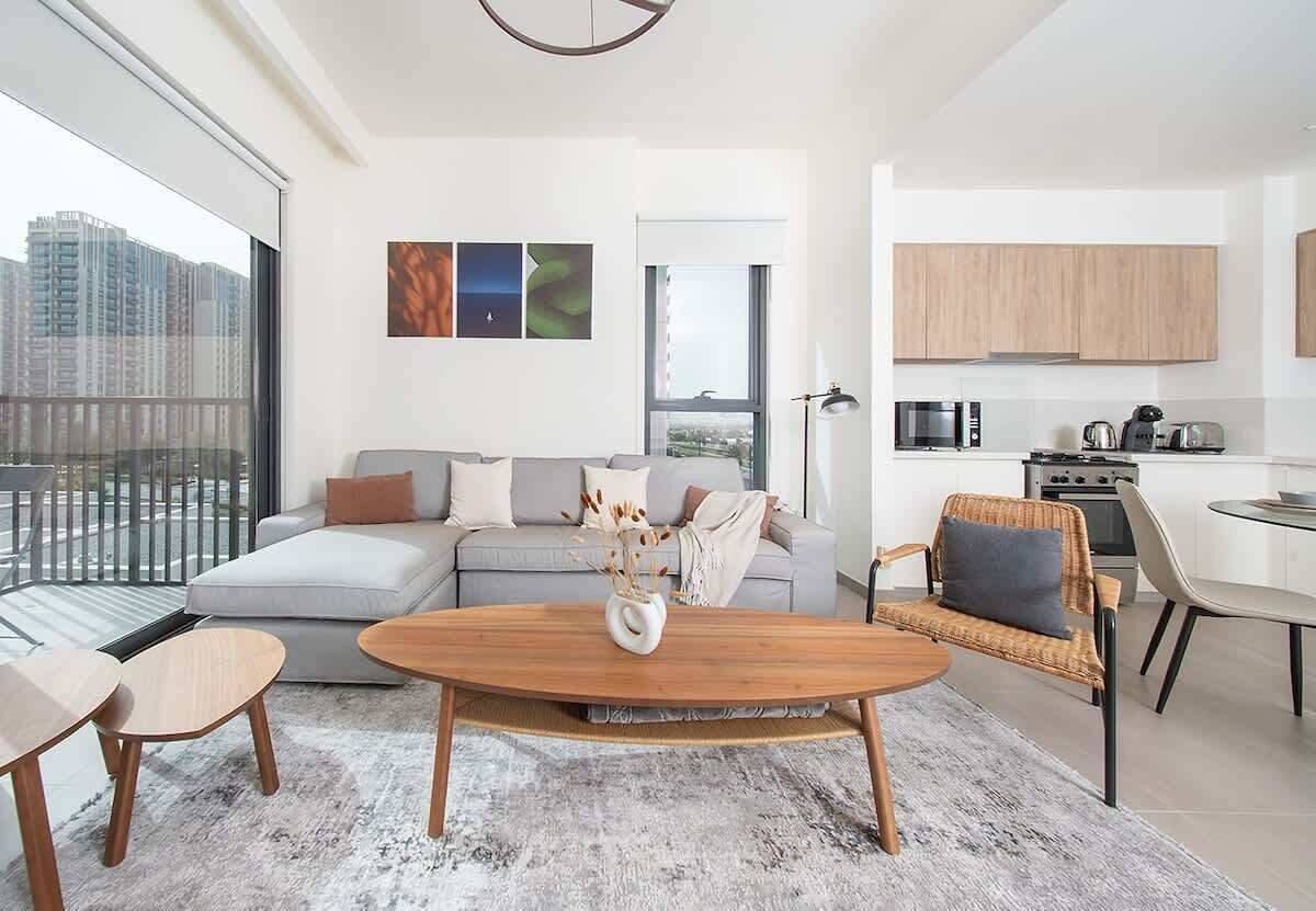 A modern apartment with a living room, dining area, and kitchen.