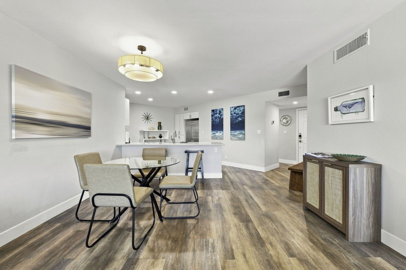 Una cocina moderna con comedor, piso de madera y decoración contemporánea.