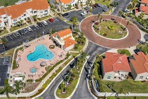 A residential area with a swimming pool, a roundabout, and a parking lot. - Updated 2BR/2BA Isla Del Sol Condo with Golf Course Views & Pool Near St. Pete Beach (Isla Del Sol)