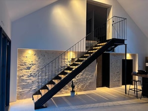 Ein modernes Interieur mit Treppe, strukturierter Wand und minimalistischem Design.