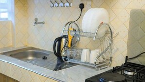 Una cucina con espositore per piatti, lavello e piano cottura.