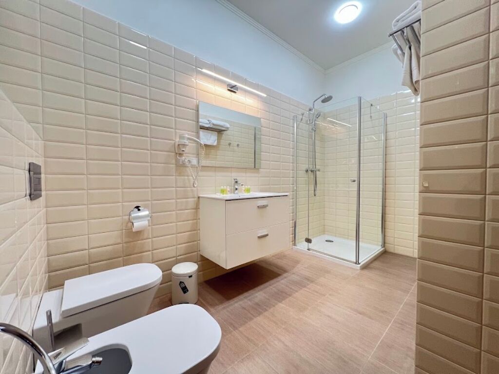 Un baño moderno con inodoro, lavamanos y zona de ducha.