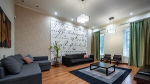 Una sala moderna con un sofá modular, una mesa de centro y una pared grande con detalles decorativos en caligrafía.
