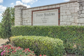 Eine Steinmauer mit einem Schild, auf dem 'Prairie Meadows at The Villages of Woodland Springs' steht.