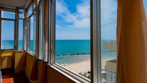 A room with a large window overlooking a beach. - GuestHost - Sea View Europa Apartment (Montesilvano)