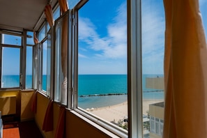A room with a large window overlooking a beach. - GuestHost - Sea View Europa Apartment (Montesilvano)
