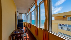 A balcony with a dining table, chairs, and curtains. - GuestHost - Sea View Europa Apartment (Montesilvano)