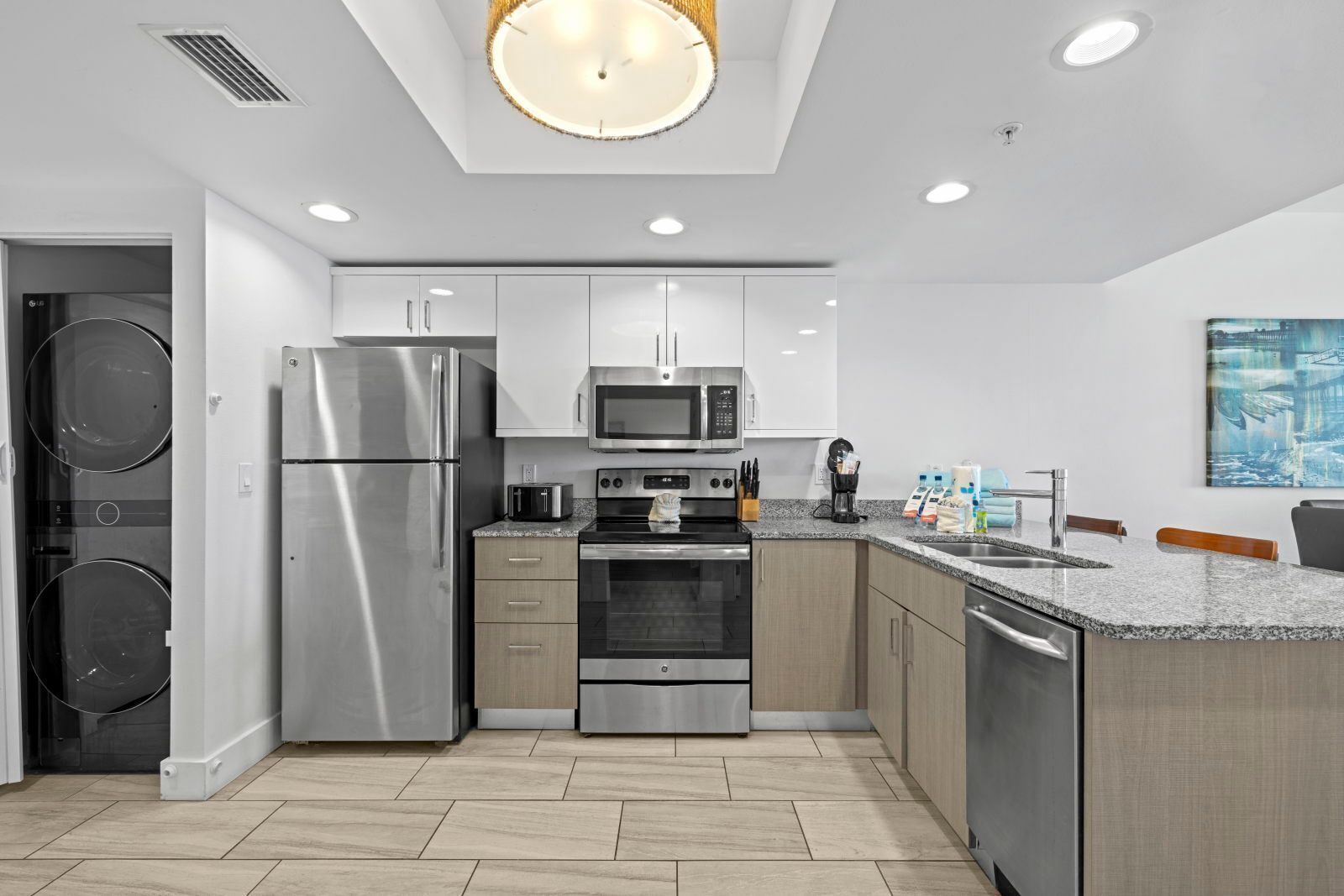 A modern kitchen with stainless steel appliances, wooden cabinets, and a granite countertop.