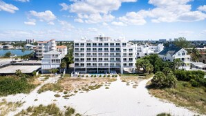 Un hotel de varios pisos con balcones, piscina y vista al mar.