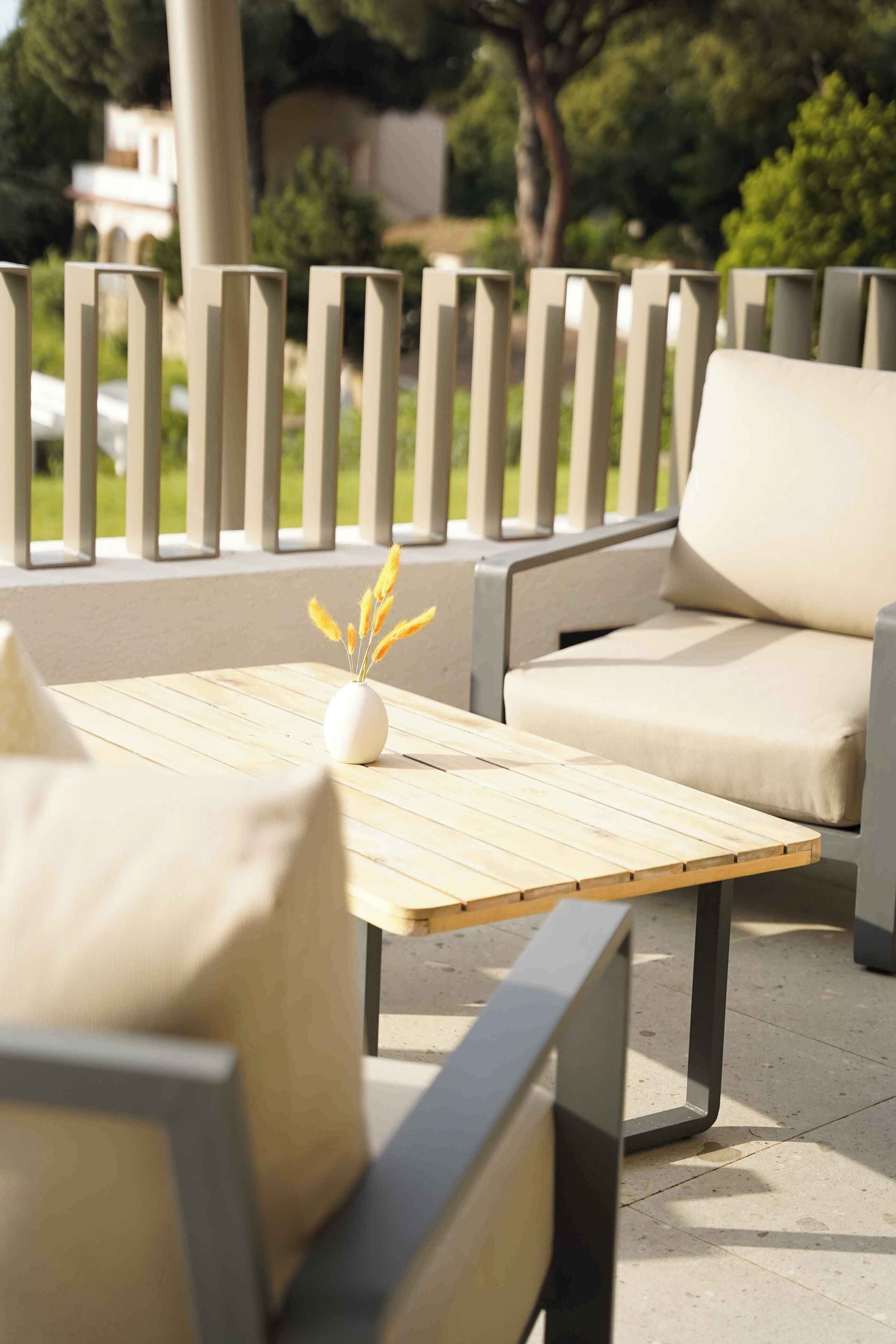 An outdoor seating area with a table, chairs, and a railing.