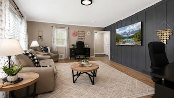 A living room with a sofa, coffee table, and a painting on the wall.