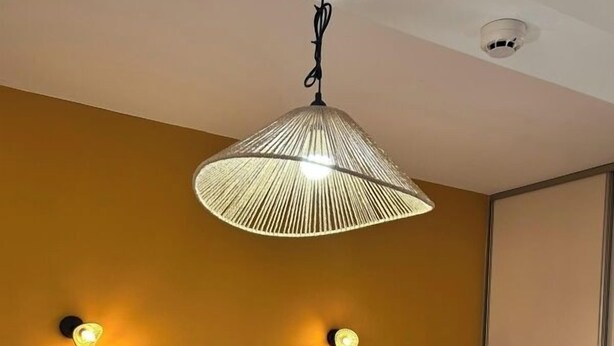 A hotel room with a bed, pillows, a folded towel, a hanging lamp, and wall sconces. - Au Bosquet Fleuri - Maison de campagne (Martizay)