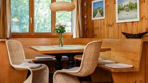 A wooden dining area with a table, chairs, and a vase of flowers. - The Deck - short walk to Elizabeth Beach - sleeps 14 - outdoor spa (Elizabeth Beach)
