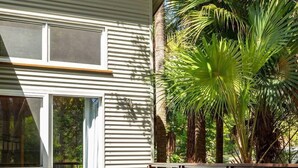 A covered outdoor area with two lounge chairs and a wooden deck. - The Deck - short walk to Elizabeth Beach - sleeps 14 - outdoor spa (Elizabeth Beach)