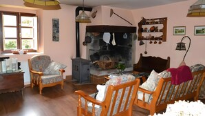 Uma sala de estar acolhedora com lareira, móveis de madeira e vista para o exterior.