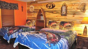 Une pièce avec deux lits, un mur en bois, une étagère et une lampe.