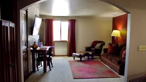 Un intérieur comprenant un bureau, une chaise, un canapé et une lampe.