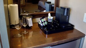 Minibar på et hotelværelse med kaffemaskine, teposer og glas.