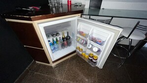 Un refrigerador compacto con varios estantes, un compartimento congelador y un cajón congelador pequeño.