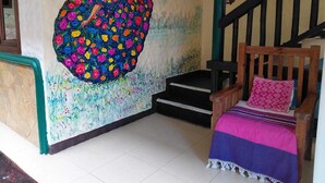 A staircase with a wooden handrail and a pink pillow on a wooden bench. - Casa Nucu Hotel (San Cristóbal de las Casas)