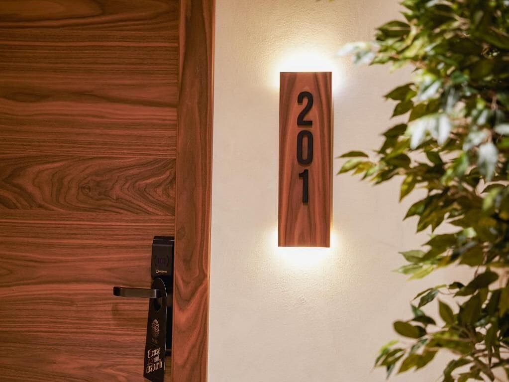 Una puerta de madera con un candado digital y el número '201' en la pared.